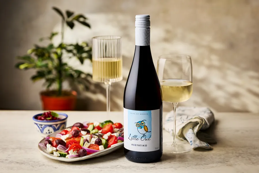 Little Owl Greek wine flat lay with Mediterranean salad and glasses